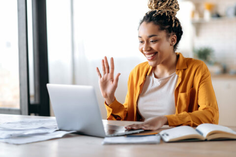 Person waving at computer screen