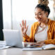 Person waving at computer screen